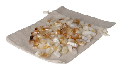Pile of tumbled citrine and quartz stones in a cloth pouch, ideal for inspiration and abundance.