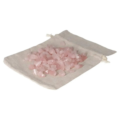 A collection of tumbled rose quartz stones on a beige cloth pouch, symbolizing love and emotional healing.