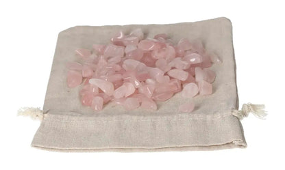 Pile of tumbled rose quartz stones on a canvas pouch, symbolizing love and healing energy