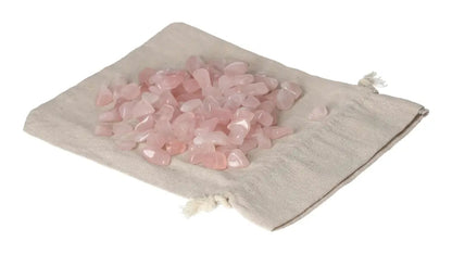 Tumbled Rose Quartz stones displayed on a beige cloth bag, symbolizing love and emotional healing with their gentle, pink hues.