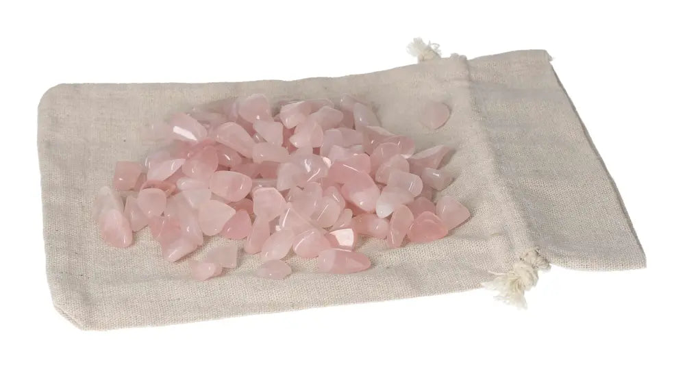 Tumbled Rose Quartz stones on a beige cloth bag, symbolizing love and emotional healing energy.