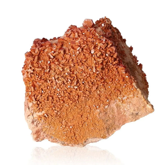 Vibrant red-orange vanadinite druzy crystal, known for focus and creativity, with unique crystalline formations on display.