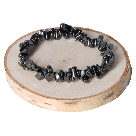 Hematite bracelet with black chips displayed on a wooden slab.