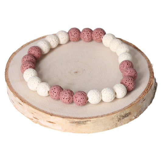 Pink and white lava bracelet with 8mm beads displayed on a wooden disc.