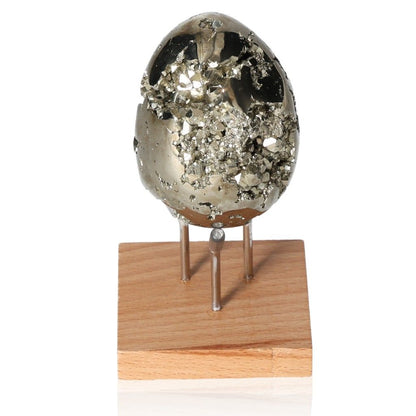 Polished pyrite egg on wooden stand, promoting independence and motivation.