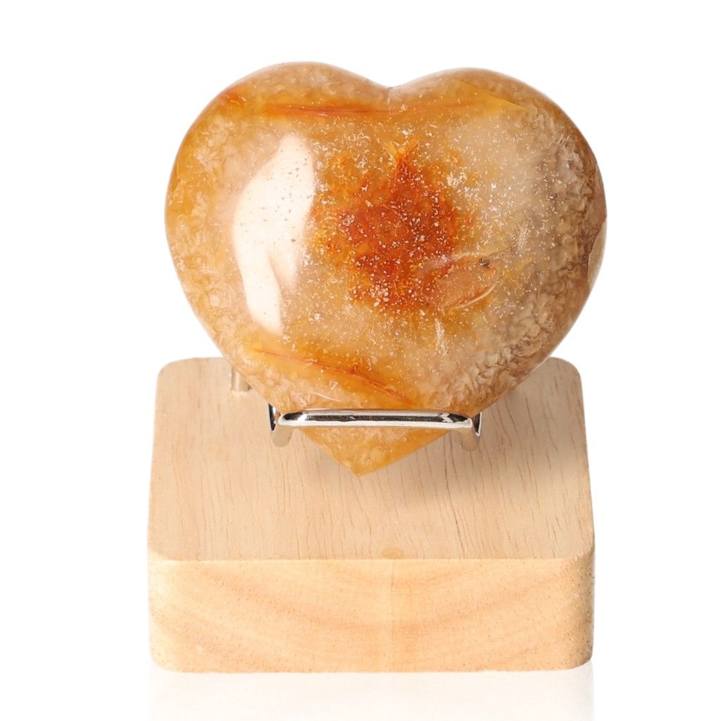 Aventurine heart-shaped stone on a wooden stand showcasing natural brown and cream patterns.