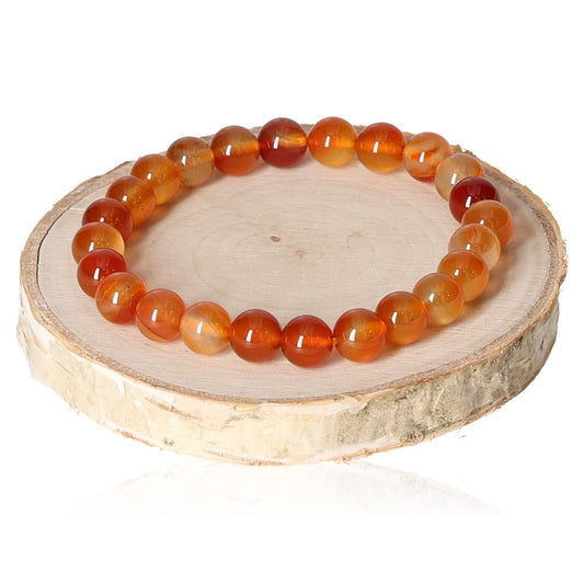 Carnelian bracelet with 8mm beads on wooden display, showcasing vibrant orange hues and natural gemstone shine.