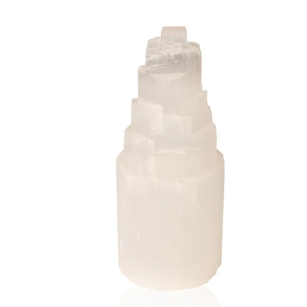 Polished selenite tower crystal with a spiral structure on a white background