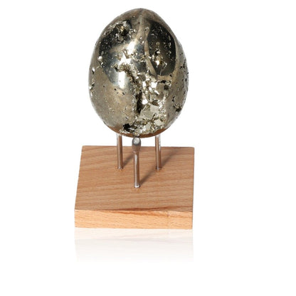 Shiny pyrite egg on wooden stand for motivation and goal achievement