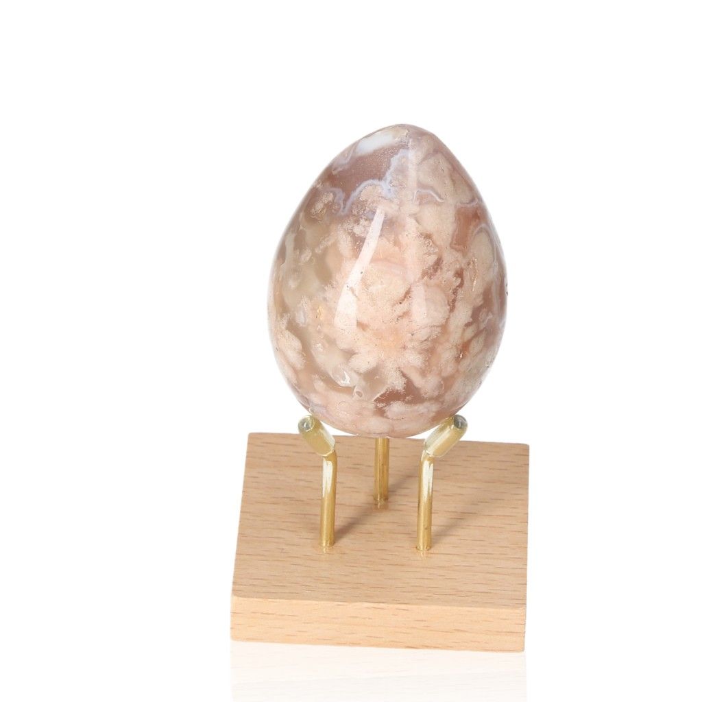 Flower Agate Egg gemstone on a wooden stand, promoting balance and serenity with its harmonious energy.