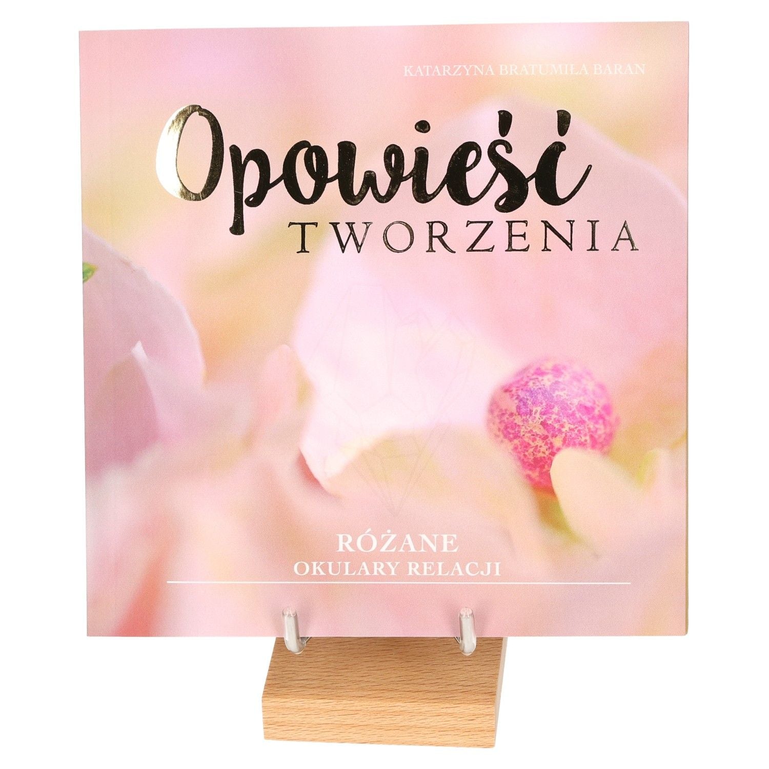 "Opowieści Tworzenia book with pink floral cover on display stand"