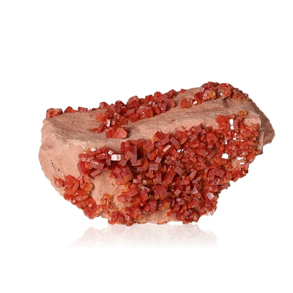 Vanadinite Druze with vibrant reddish-brown hexagonal crystals, enhancing focus and motivation, on a glassy surface.