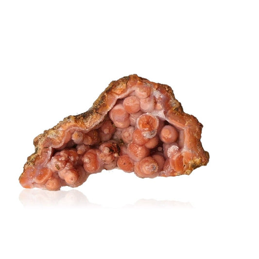 Vibrant pink calcite stalactite crystal formation with spherical clusters on a white background.