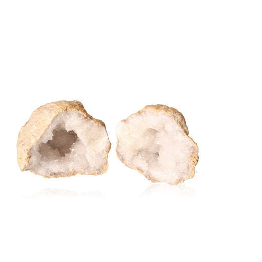 Milky quartz geodes with sparkling white crystals, known for purifying energy and enhancing tranquility, displayed against a white background.