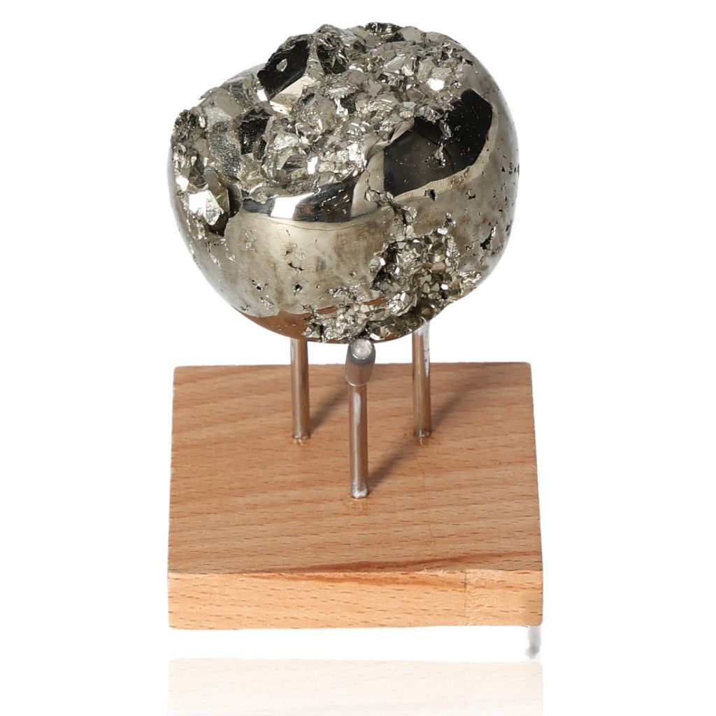 Pyrite sphere on wooden stand, shimmering with metallic luster, promoting independence and inspiring new ideas and action.