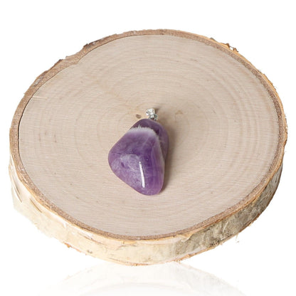 Amethyst Malawi tumbled pendant on wooden slab background.