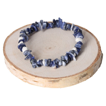 Sodalite gemstone bracelet with natural stone chips displayed on a wooden slab.