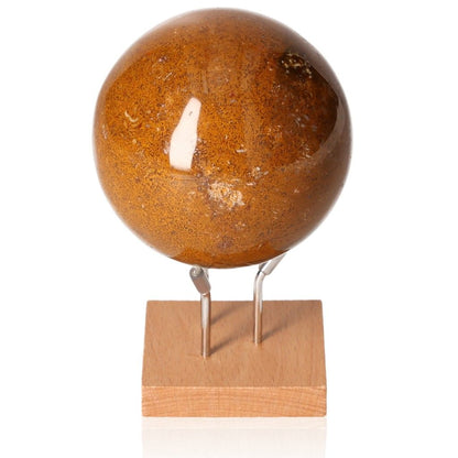 Polished brown gemstone sphere on wooden stand, showcasing its unique patterns and glossy finish.