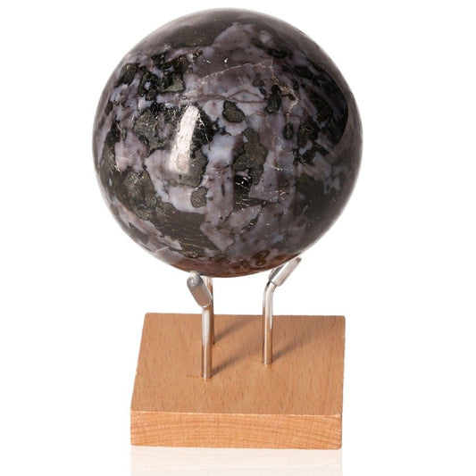 Indigo Gabbro Sphere on wooden stand, featuring swirling black and indigo patterns, known for enhancing intuition and spiritual growth.