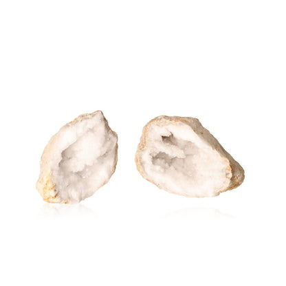 Two open milky quartz geodes displaying sparkling white crystals, known for purifying energy and enhancing tranquility and focus.