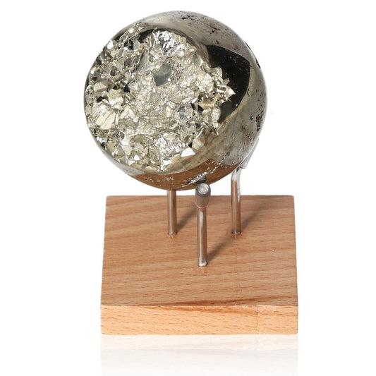 Shimmering pyrite sphere on a wooden stand, promoting independence and courage in decision-making.