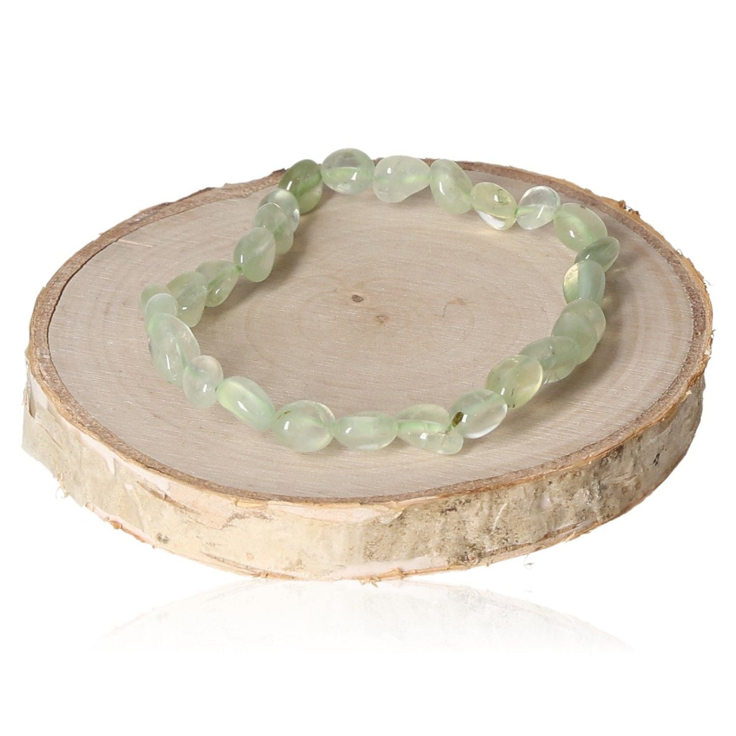 Prehnite tumbled bracelet displayed on a wooden platform.