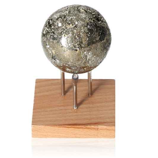 Pyrite sphere on wooden stand, believed to inspire new ideas and courage, enhancing independence and initiative.