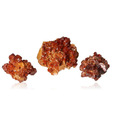 Reddish-brown Vanadinite small druzes with vibrant hexagonal crystals on a white background, showcasing geometric shapes and glassy surfaces.