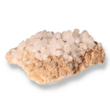 Rough quartz cluster showcasing unique crystal formations on a beige rock base.