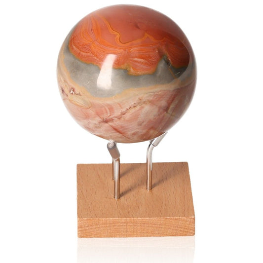 Polychrome Jasper Sphere with vibrant red, orange, and brown banded patterns on a wooden stand, known for grounding and energizing properties.