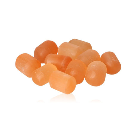 Himalayan salt massage stones in a scattered arrangement on a white background