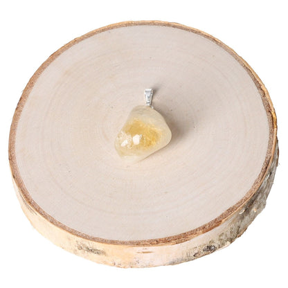 Citrine tumbled pendant displayed on a round wooden slab for a natural look.