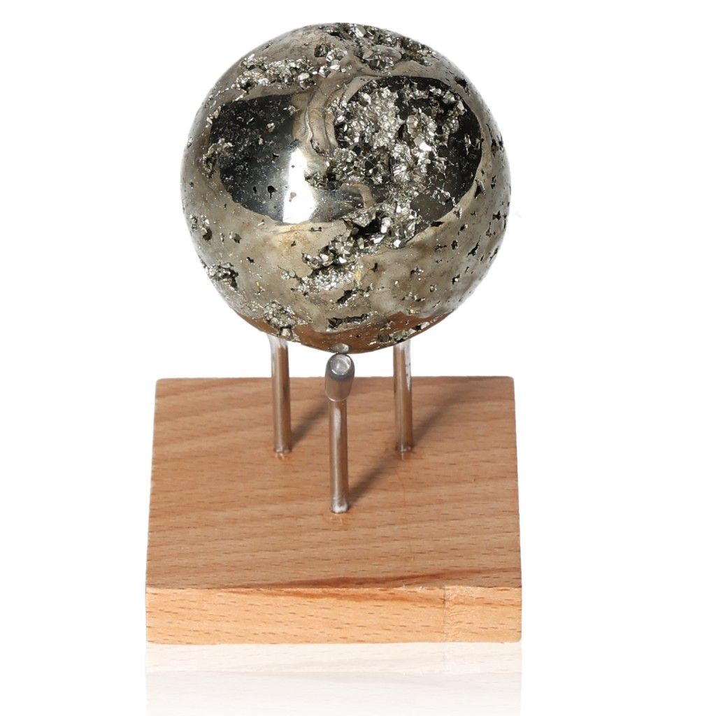 Shimmering pyrite sphere on wooden stand, promoting independence and courage through its inspiring energy.