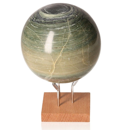 Green onyx sphere on wooden stand, promoting strength, determination, and self-discipline by releasing past burdens and guilt.