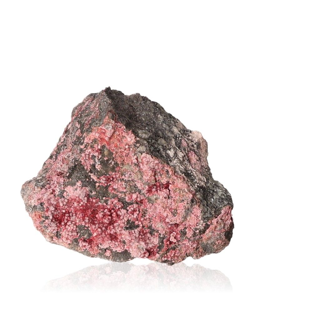 Pink and black mineral rock showcasing a rough texture with crystalline formations on a white background.