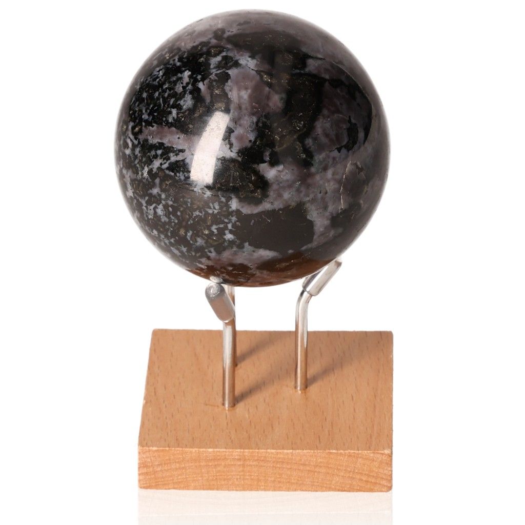 Indigo Gabbro sphere on wooden stand showcasing swirling patterns, known as Mystic Merlinite for intuition and spiritual growth.