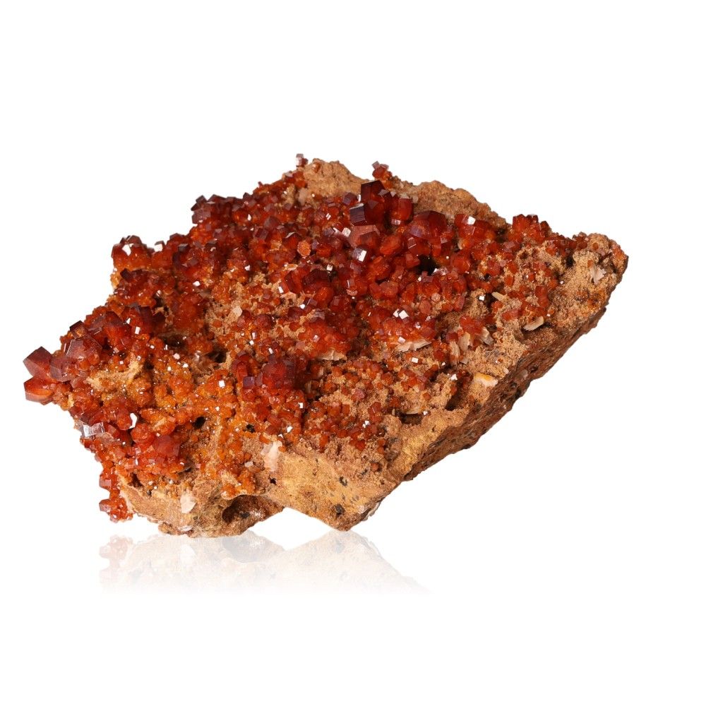 Vanadinite Druze with vibrant reddish-brown crystals on a rock base, showcasing its hexagonal shapes and glassy surface.