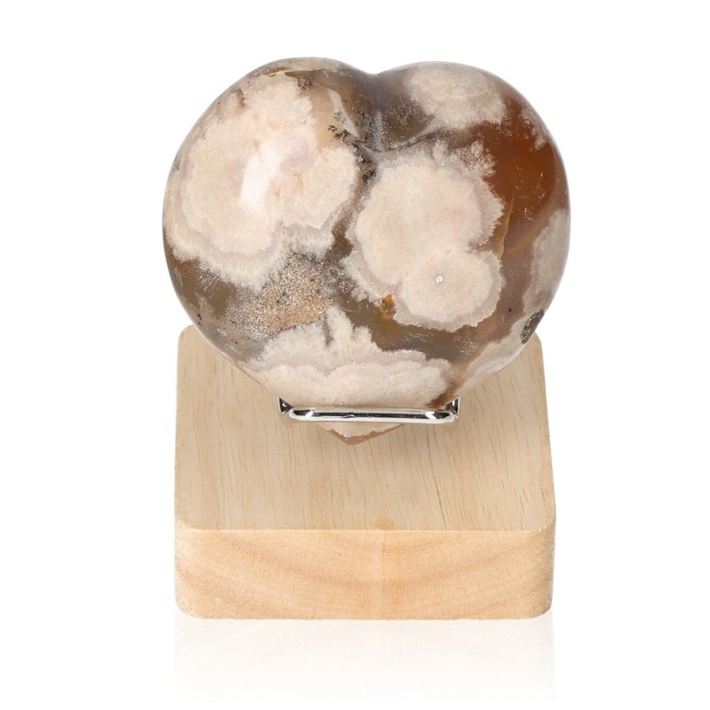 Heart-shaped Flower Agate gemstone on a wooden stand, showcasing calming patterns and earthy colors for serenity and balance.