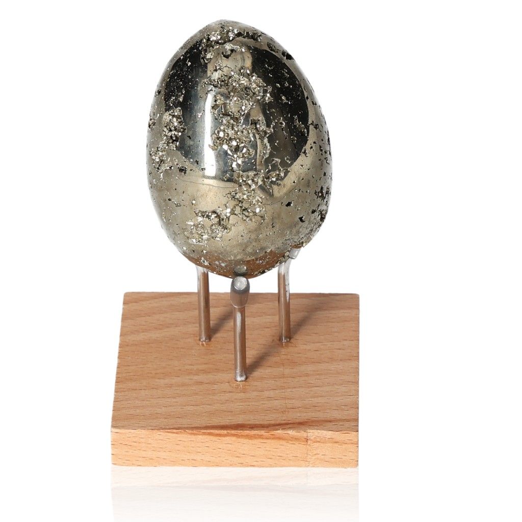 Pyrite egg displayed on wooden stand, promotes independence and courage for goal achievement, ideal for overcoming fear of failure.