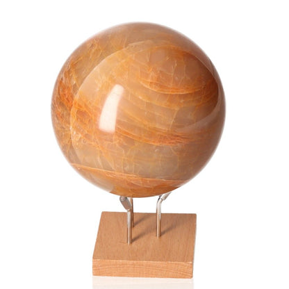 Golden Healer Quartz Moon Stone Sphere on wooden stand for spiritual healing and stress relief.