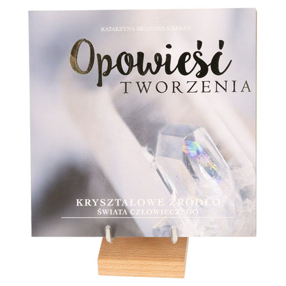 "The Crystal Source of Life book cover on wooden stand with abstract crystal imagery"