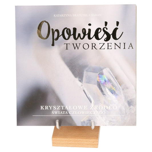 "The Crystal Source of Life book cover on wooden stand with abstract crystal imagery"